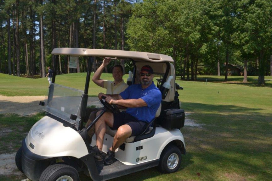 Golfers on golf cart at CRMC's 2019 Golf Classic event