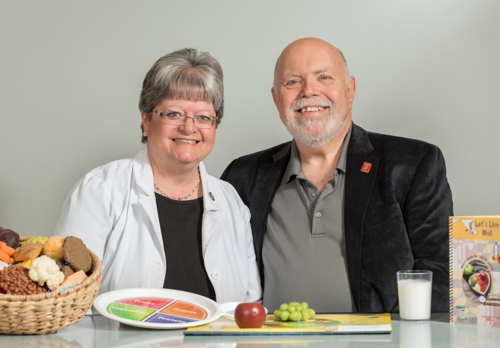 Colan Ratliff and Cindy Adams in front of a mock plate of food